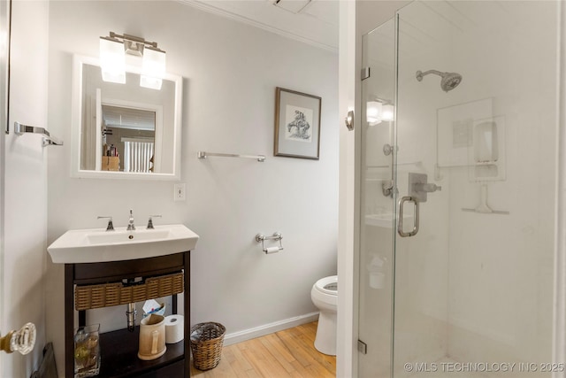 bathroom featuring sink, hardwood / wood-style flooring, ornamental molding, walk in shower, and toilet