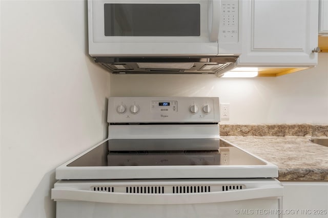 room details featuring white cabinetry and white appliances