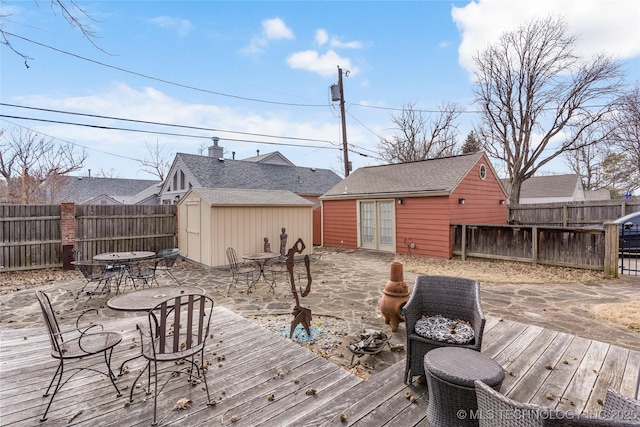 wooden terrace featuring french doors and a storage unit