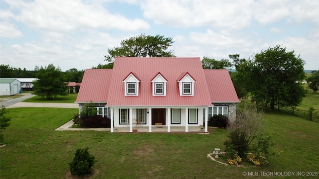 rear view of house featuring metal roof, a porch, and a lawn