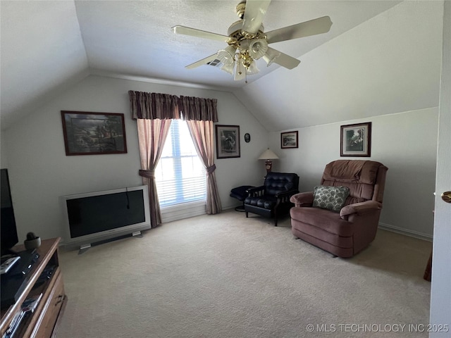 living area featuring ceiling fan, vaulted ceiling, light carpet, and a textured ceiling