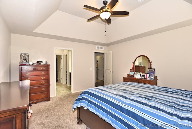 carpeted bedroom featuring ceiling fan and a tray ceiling