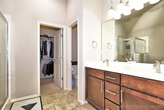 bathroom with vanity, toilet, tile patterned floors, and walk in shower