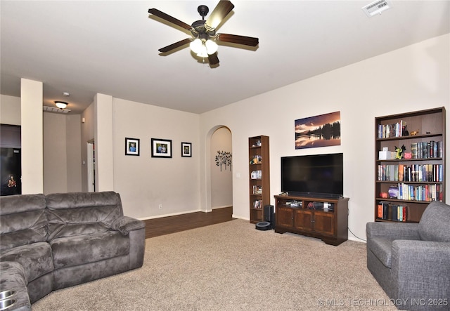 carpeted living room with ceiling fan