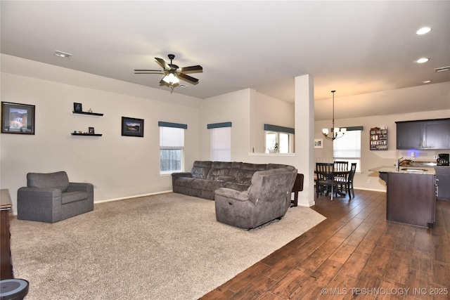 living room featuring sink, ceiling fan with notable chandelier, a wealth of natural light, and dark hardwood / wood-style floors