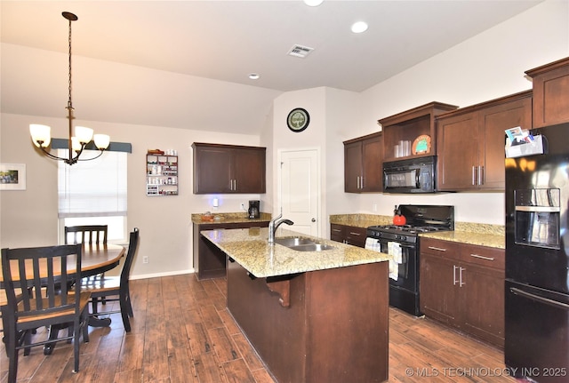 kitchen with sink, dark wood-type flooring, black appliances, and hanging light fixtures