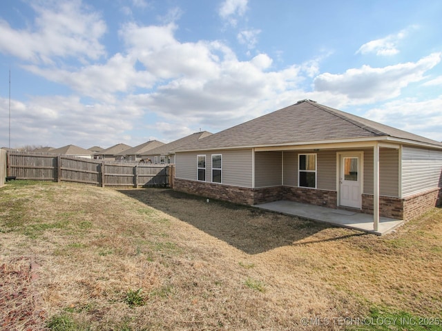 rear view of property featuring a yard and a patio