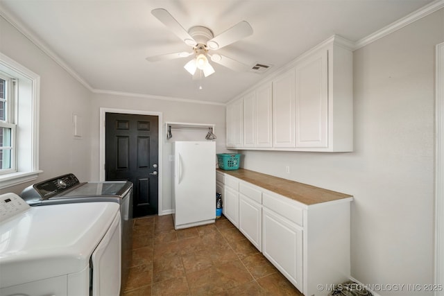 clothes washing area with visible vents, ornamental molding, a ceiling fan, cabinet space, and washer and clothes dryer