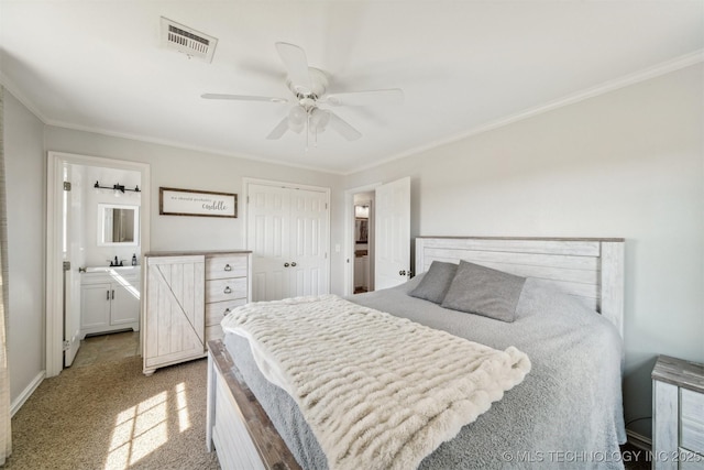 carpeted bedroom with crown molding, ceiling fan, ensuite bathroom, and a closet