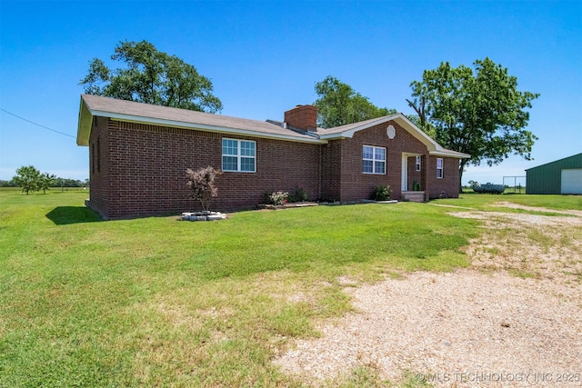 ranch-style home with brick siding, a chimney, and a front yard