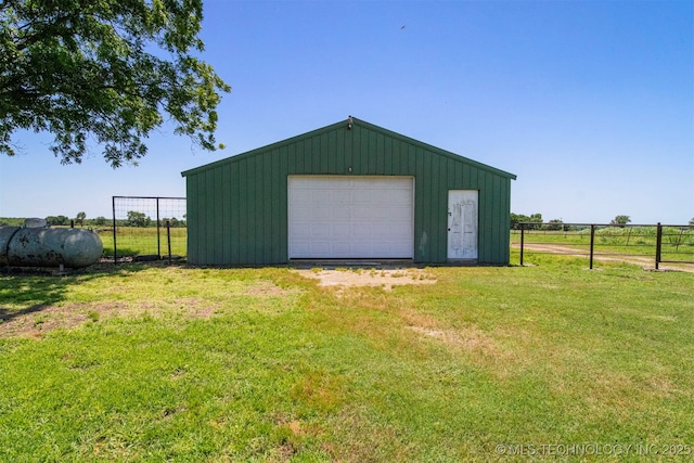 detached garage featuring driveway and fence