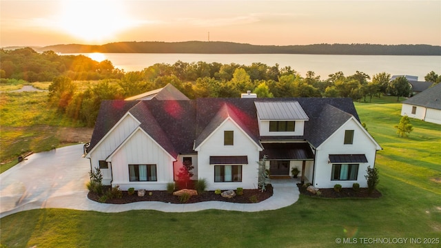 view of front of property with a water view and a yard