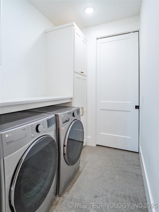 clothes washing area with cabinets and washing machine and dryer