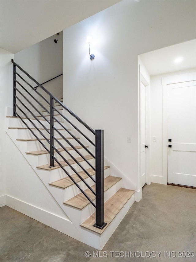 staircase featuring concrete flooring