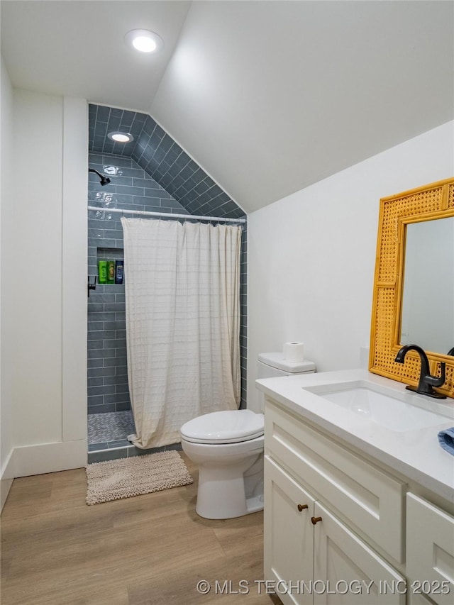 bathroom featuring lofted ceiling, curtained shower, wood-type flooring, and toilet