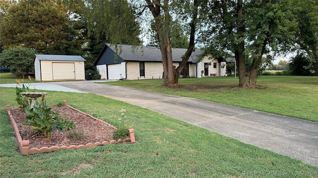 view of front facade with an outbuilding, a garage, and a front yard