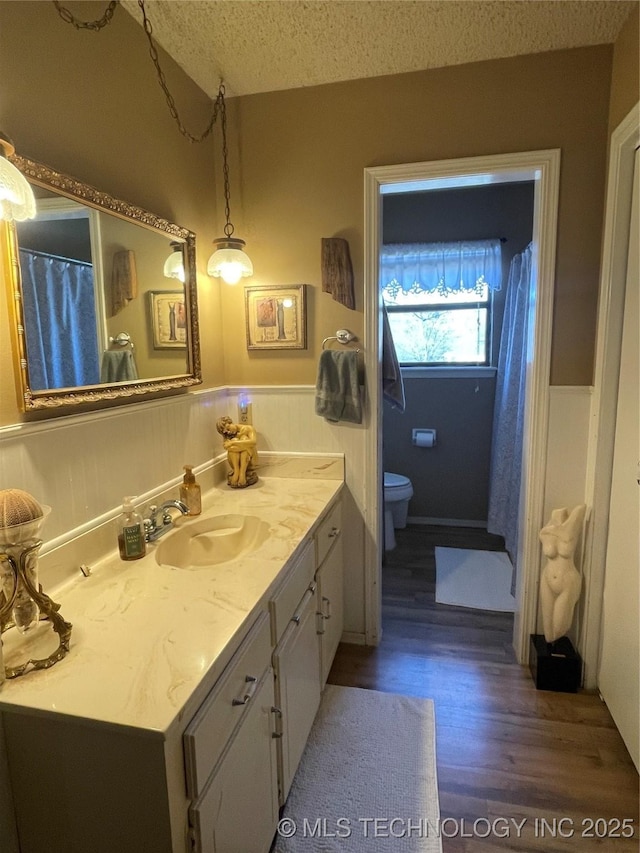 bathroom featuring vanity, a textured ceiling, toilet, and hardwood / wood-style flooring