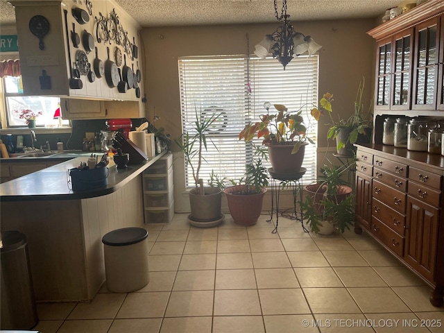 kitchen with light tile patterned floors, sink, and a textured ceiling