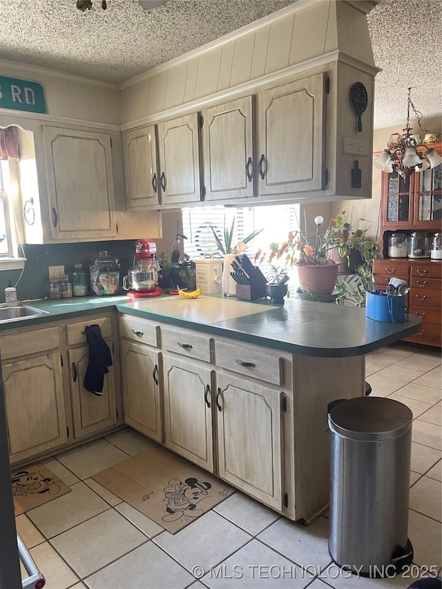 kitchen featuring kitchen peninsula, sink, a textured ceiling, and light tile patterned floors