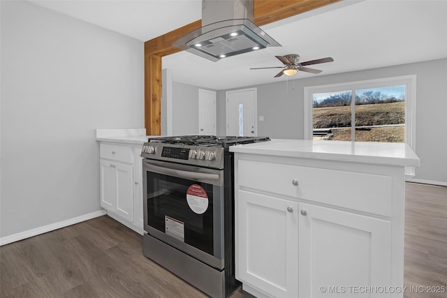 kitchen featuring dark wood-type flooring, island exhaust hood, gas stove, and white cabinets