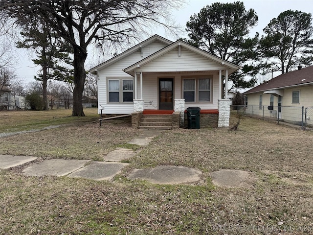 bungalow with a porch and a front lawn