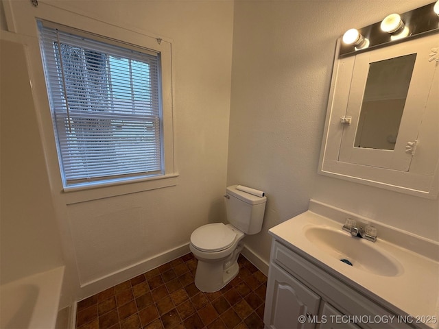 bathroom featuring vanity, a bathtub, and toilet