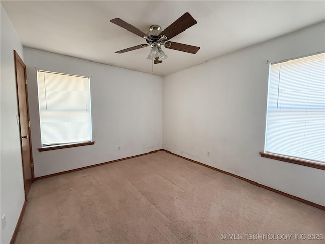 carpeted empty room featuring a healthy amount of sunlight and ceiling fan