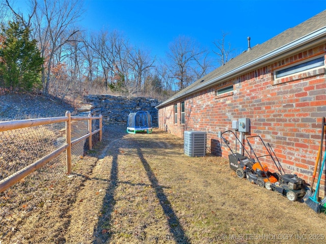 view of yard with a trampoline and central AC unit