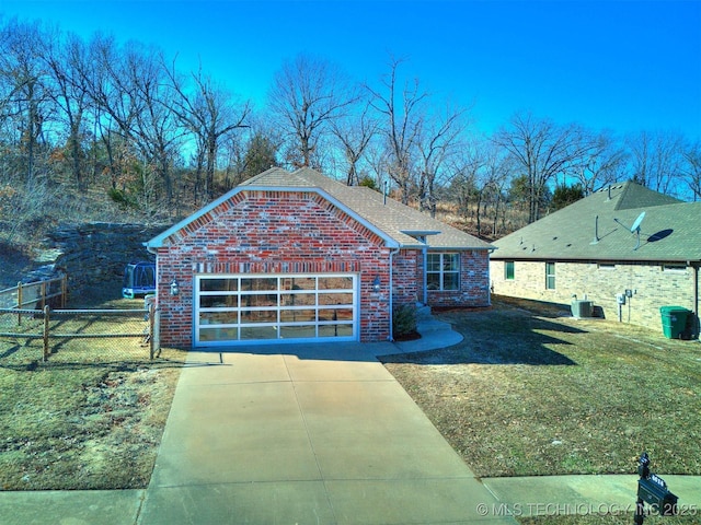 view of front of house featuring a garage, cooling unit, and a front lawn