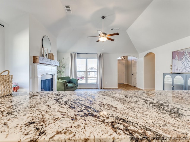 unfurnished living room featuring lofted ceiling, ceiling fan, and light hardwood / wood-style floors