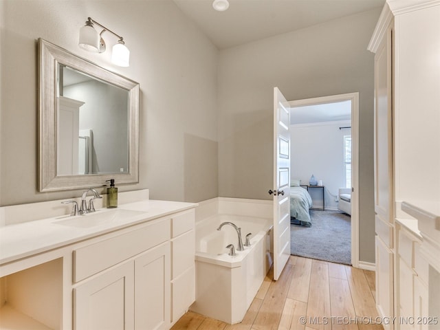 bathroom featuring hardwood / wood-style flooring, vanity, and a tub