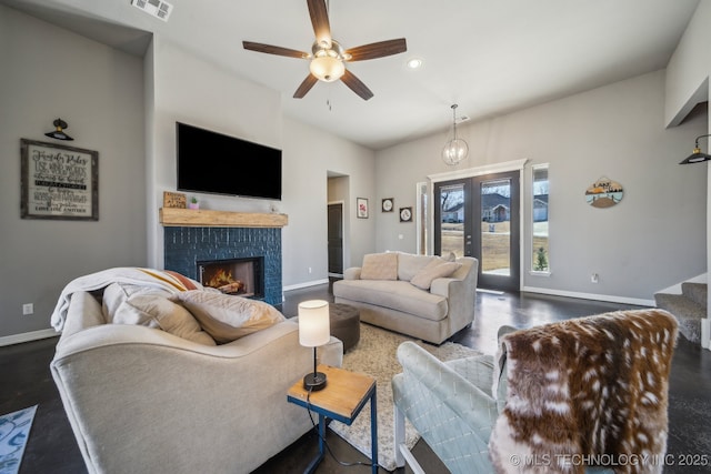 living room featuring french doors, ceiling fan, and a brick fireplace