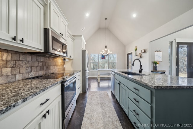 kitchen featuring sink, decorative light fixtures, a center island with sink, stainless steel appliances, and white cabinets