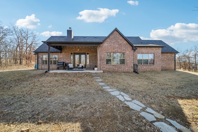 back of property with a patio and a yard