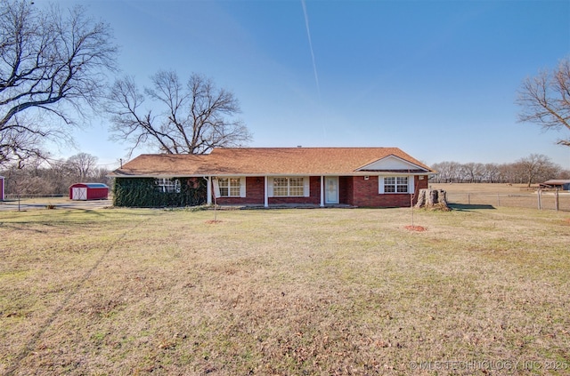 view of front of home with a storage shed and a front lawn