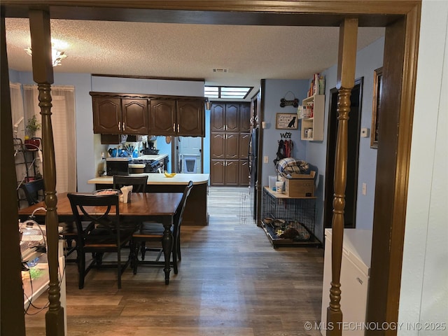 dining area featuring dark wood-type flooring and a textured ceiling