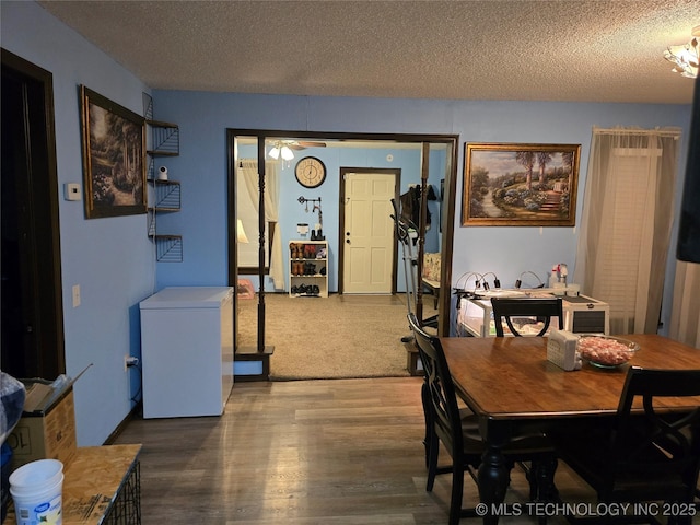 dining area with dark hardwood / wood-style floors and a textured ceiling