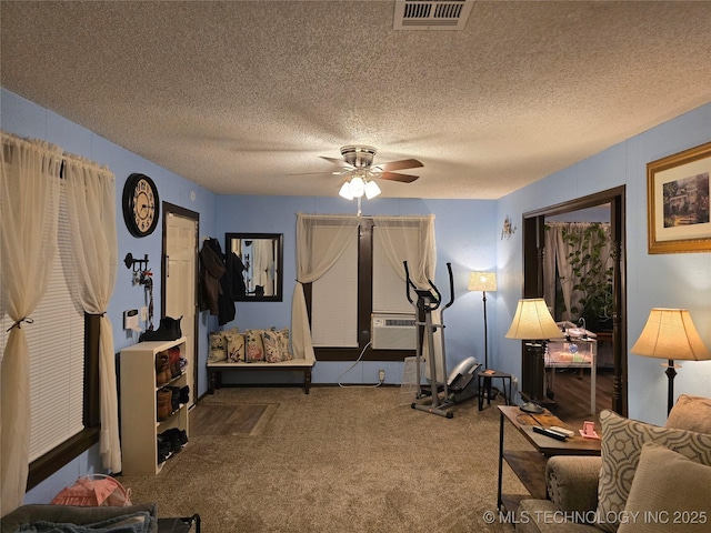 exercise room featuring ceiling fan, carpet floors, cooling unit, and a textured ceiling