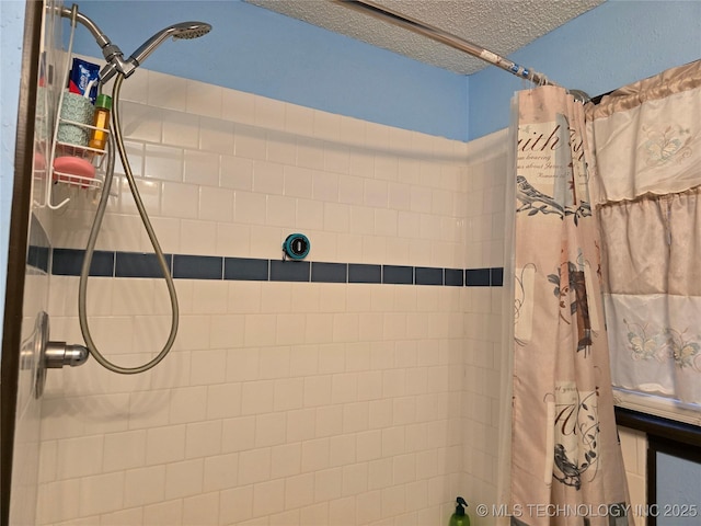 bathroom featuring curtained shower and a textured ceiling