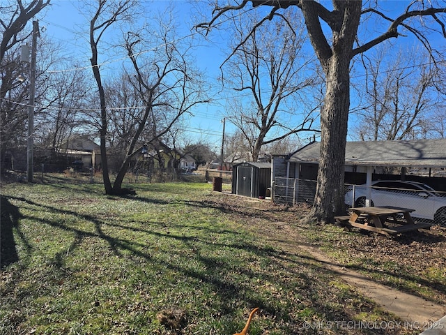 view of yard featuring a carport and a storage unit