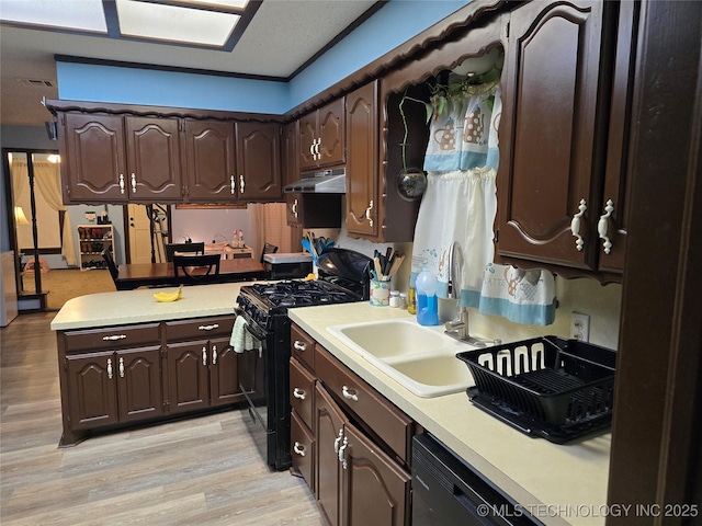 kitchen featuring dark brown cabinetry, sink, black appliances, and light hardwood / wood-style floors