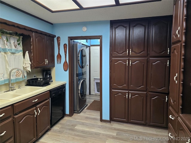 kitchen with stacked washer and dryer, sink, dark brown cabinets, black dishwasher, and light hardwood / wood-style floors