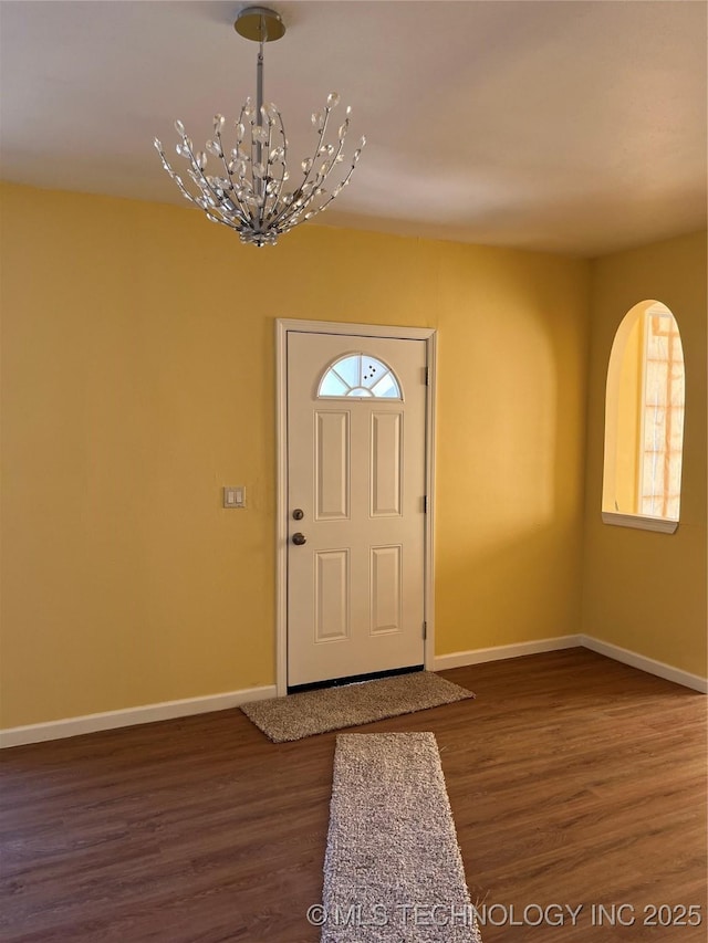 foyer entrance featuring dark hardwood / wood-style flooring and a notable chandelier