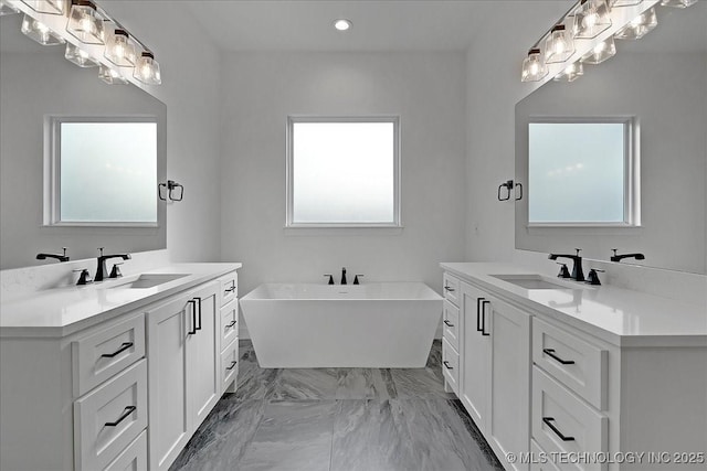 bathroom with vanity, a wealth of natural light, and a tub