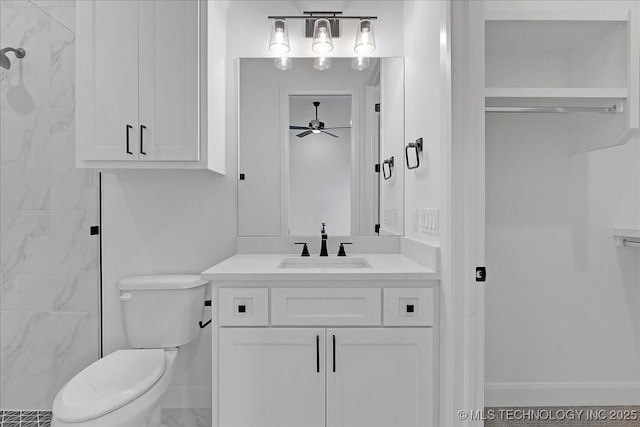 bathroom featuring vanity, tiled shower, ceiling fan, and toilet