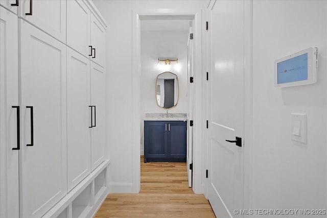 mudroom with sink and light hardwood / wood-style floors