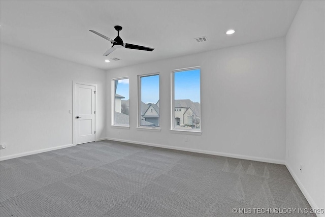 spare room with ceiling fan and light colored carpet