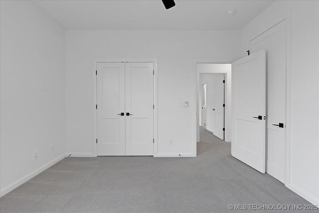 unfurnished bedroom featuring light colored carpet, ceiling fan, and a closet