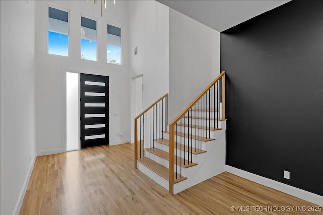 entryway featuring a high ceiling and light hardwood / wood-style floors