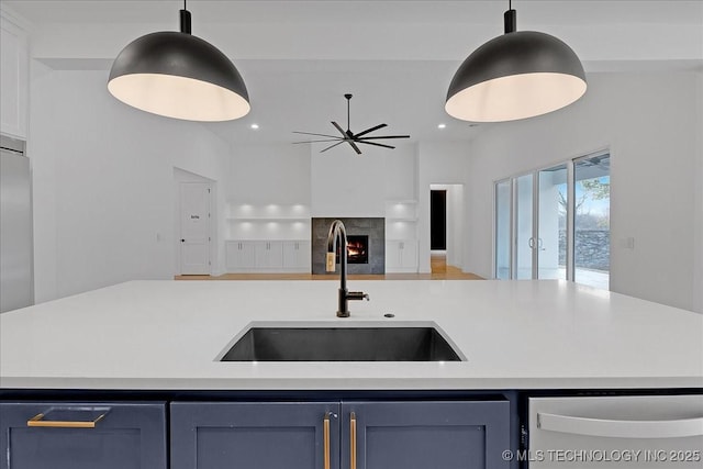 kitchen with pendant lighting, blue cabinets, dishwasher, and sink